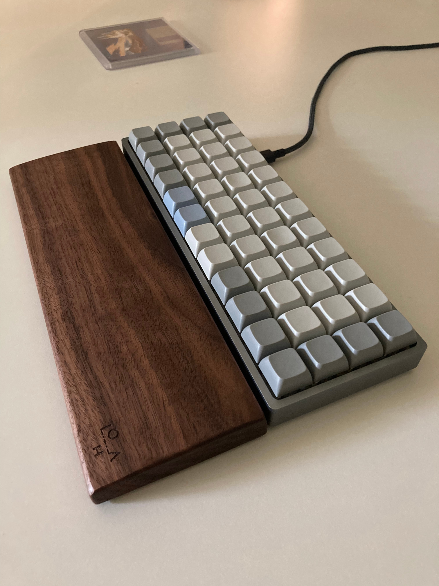 Picture of my Planck with blank XDA keycaps and wooded wrist rest.